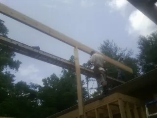 Carpenter setting a ridge beam over a new addition frame — Ice Dam Removal by Roofing Brothers in Granbury