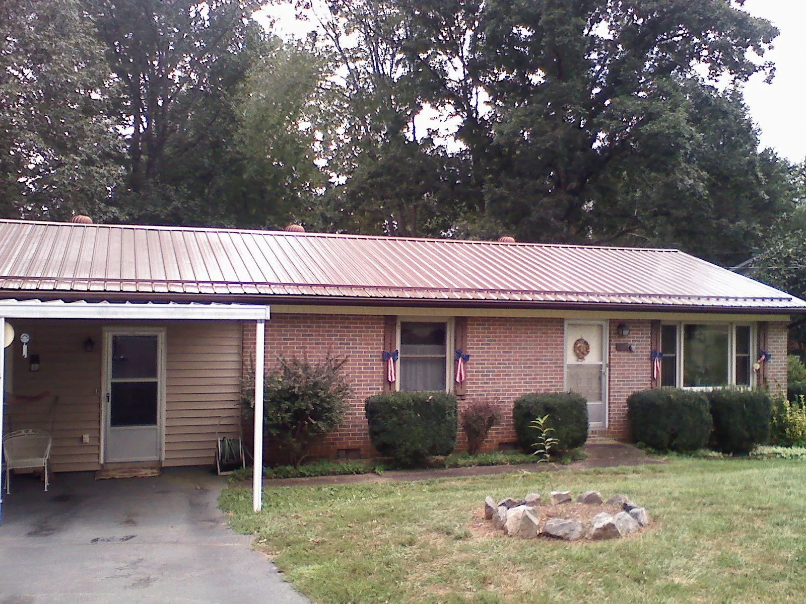Bronze metal roof and carport on a brick ranch home — Roof Repair work by our crew in Granbury
