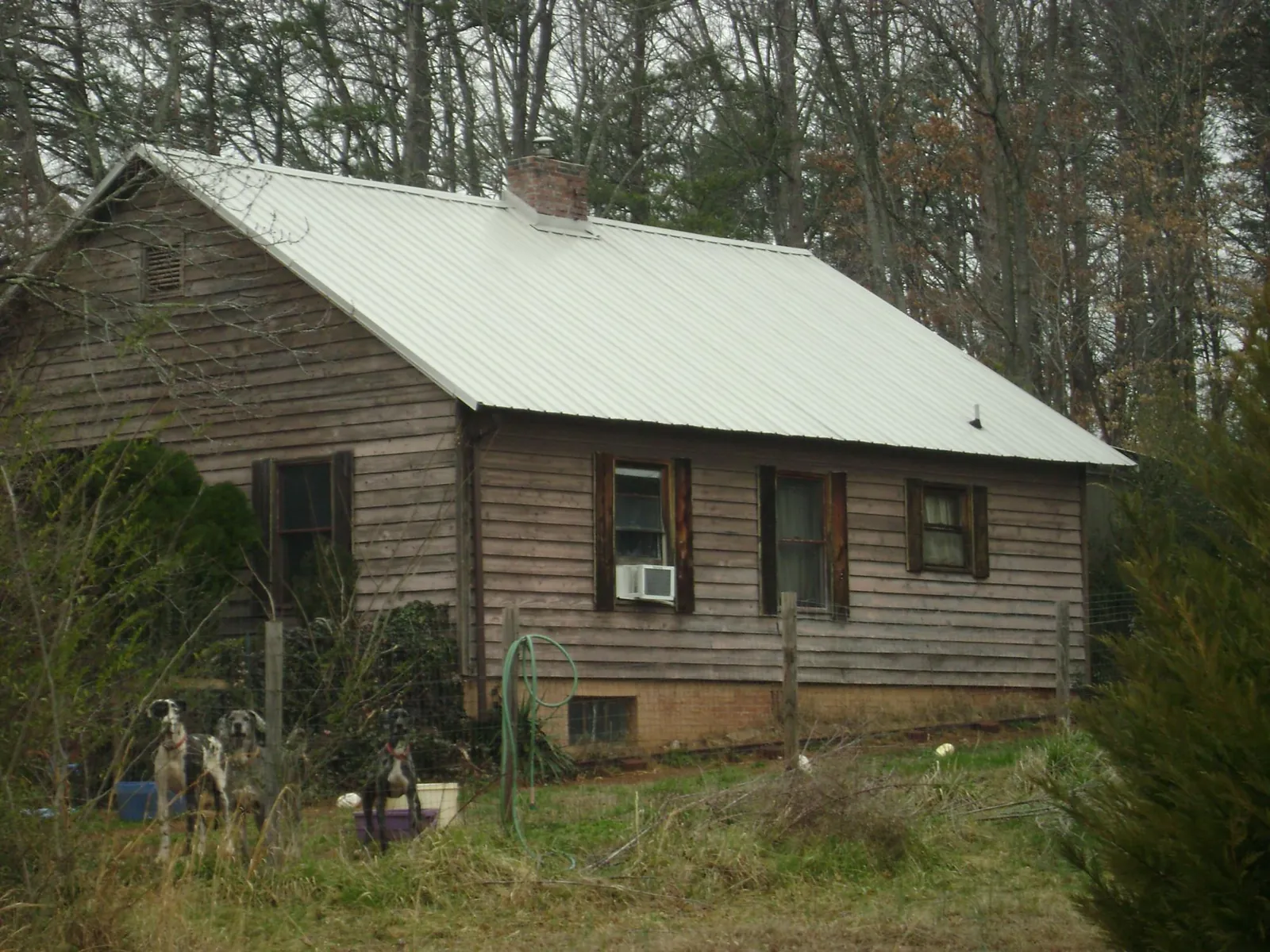 White metal roof on an old wood sided farmhouse, from a Metal Roof Installation job in Granbury